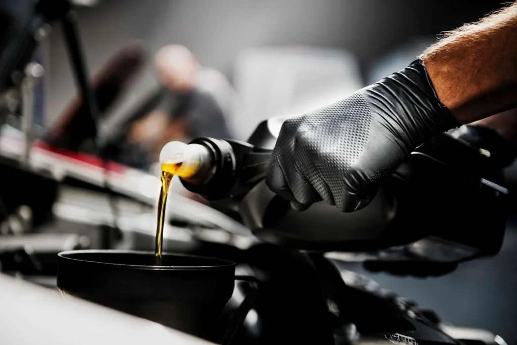 Heavy-duty Mercator Ideall Grip disposable nitrile gloves in black and blue, showcasing the specialized 3D diamond textured grip pattern on a professional workshop workbench.