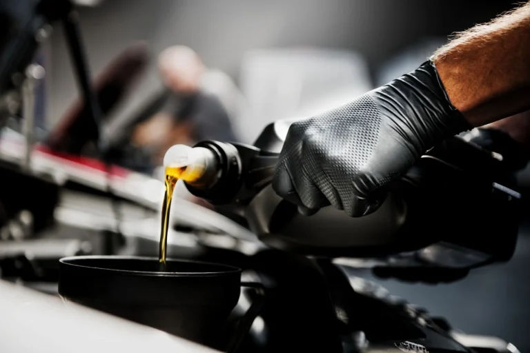 Heavy-duty Mercator Ideall Grip disposable nitrile gloves in black and blue, showcasing the specialized 3D diamond textured grip pattern on a professional workshop workbench.