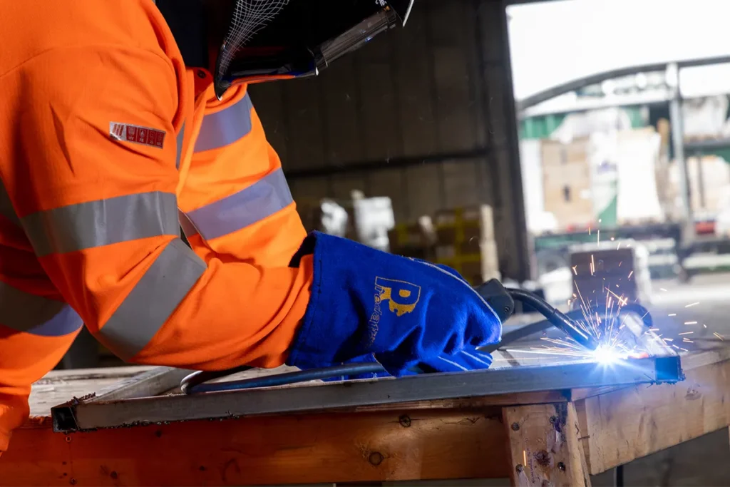 Man wearing blue lightning welding safety gloves